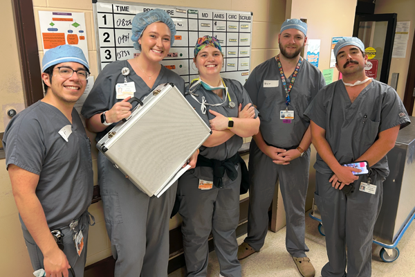 Residents in scrubs in a hallway