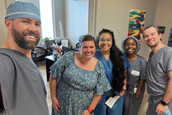 Residents in scrubs with program manager