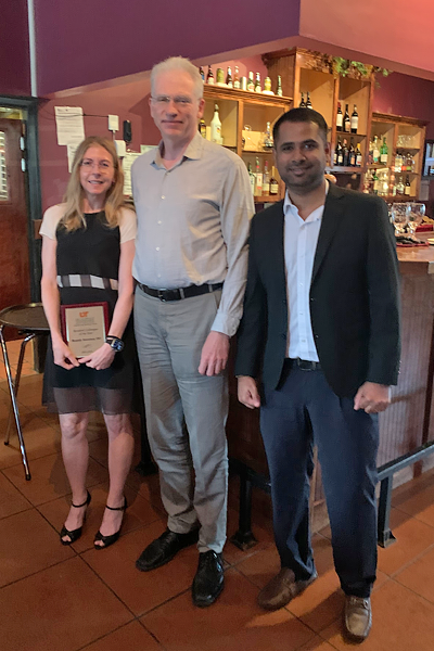 Resident with faculty during graduation