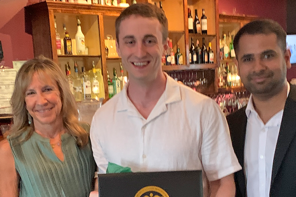 Resident with faculty at graduation