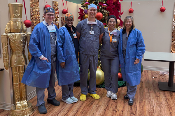 Residents in scrubs with holiday decorations and a nutcracker in the background