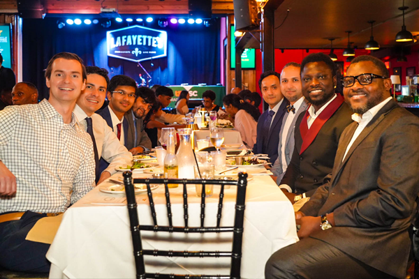 Group of fellows dining and listening to music at Lafayette's Music Room with a stage in the background