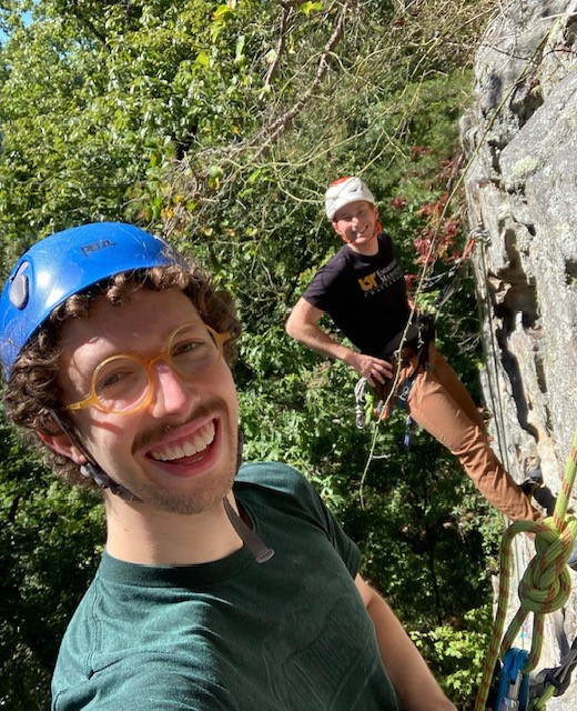 A couple of rock climbers on a cliff face.