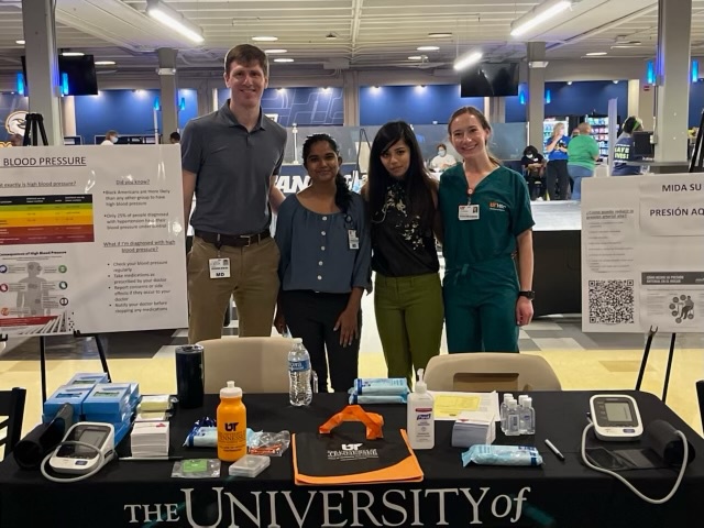 Four residents at UTHSC table at event.