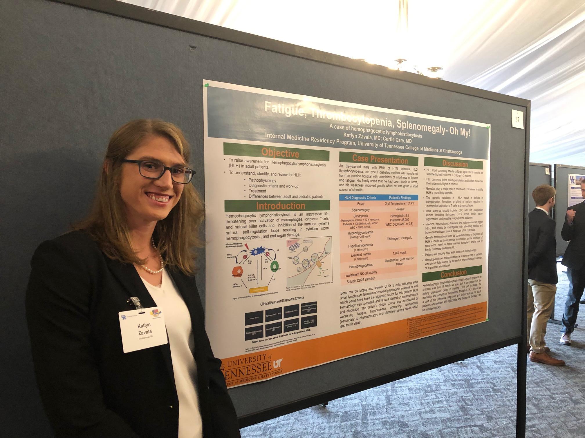 Katlyn Zavala in front of her presentation board about hemophagocytic lympohistiocytosis