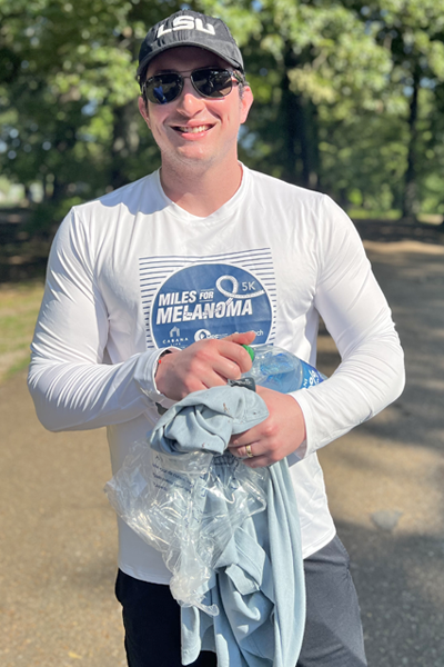 Male resident outside holding a water bottler after a run