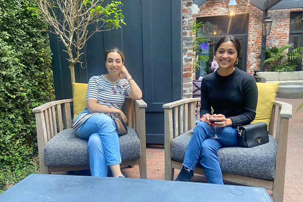 Two female residents sitting on chairs on an outside patio