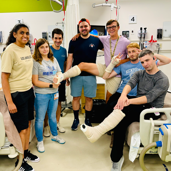 Residents together in a clinical setting and two have casts on their legs