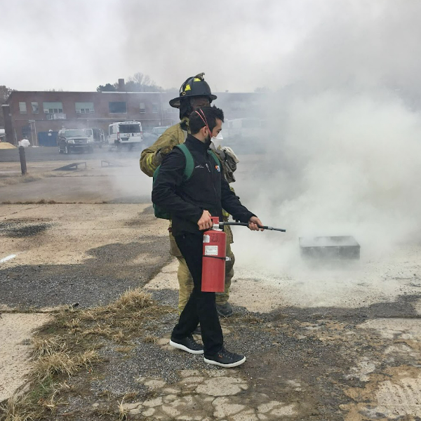 Resident helping a firefighter put out a grass fire