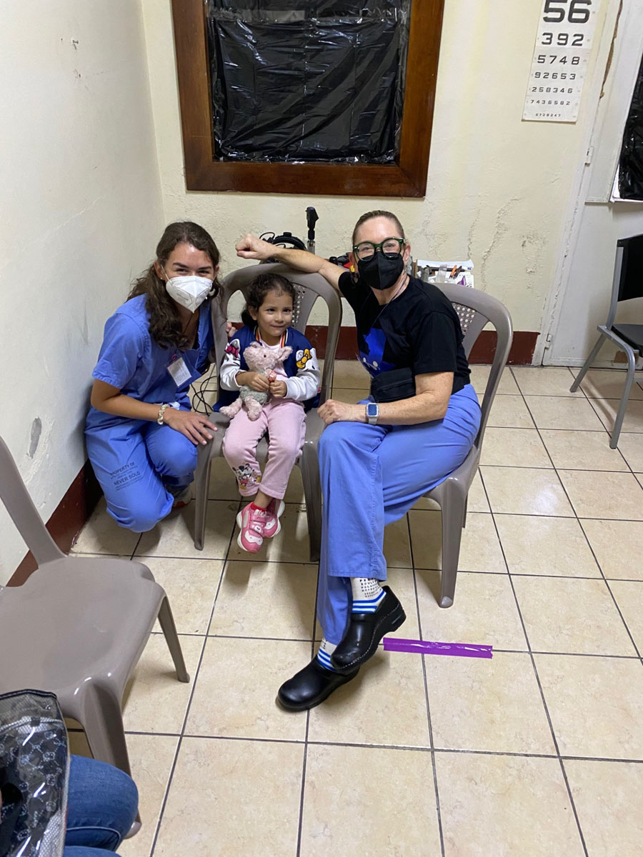 Two doctors sitting with child patient.