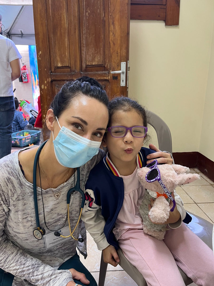 Doctor sitting with smiling child patient.