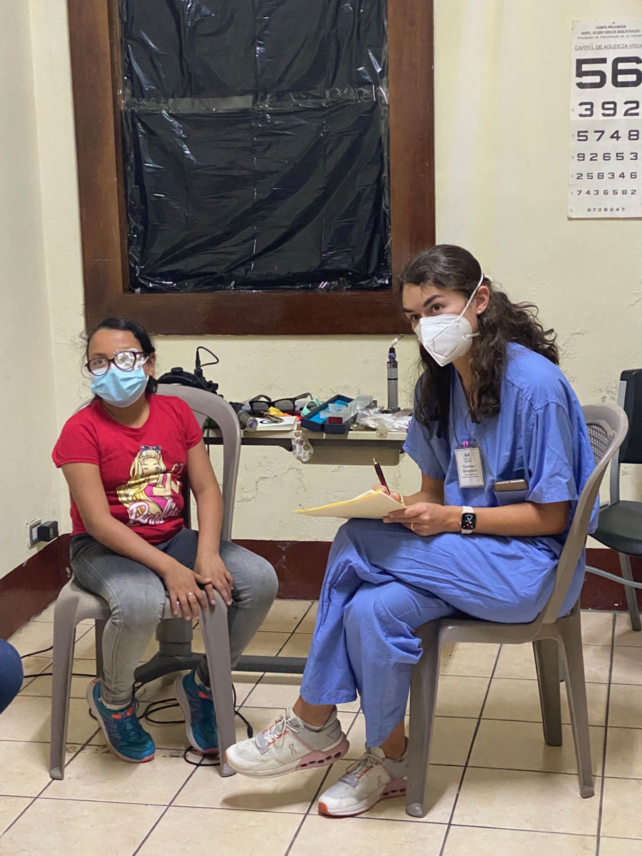 Doctor taking notes and talking to child patient.