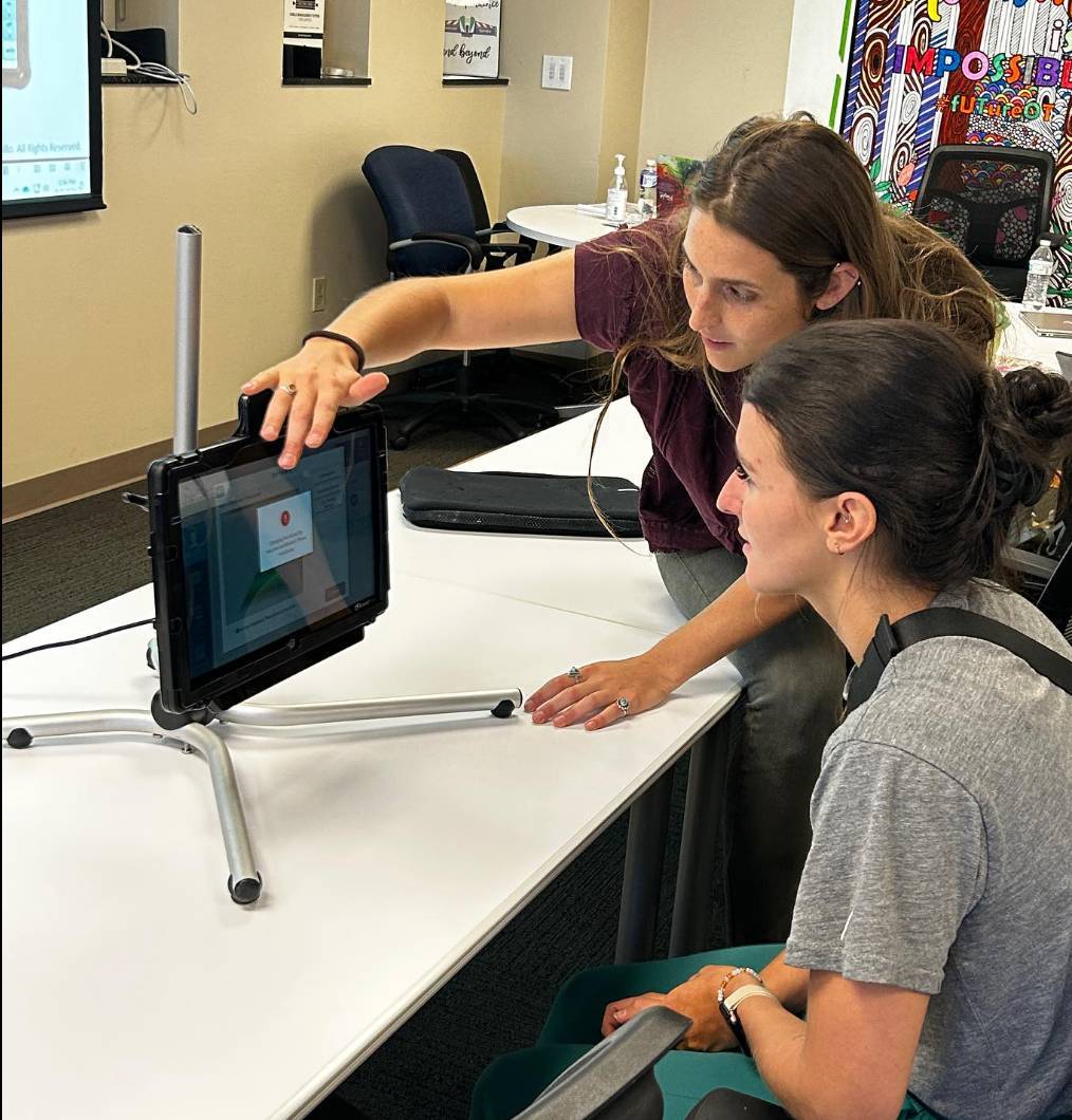Two students working together at a monitor.