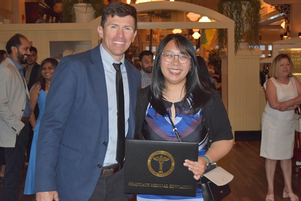 Female fellow holding certificate next to a faculty member