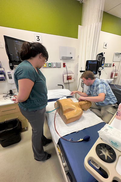 Resident and instructor over a sim dummy