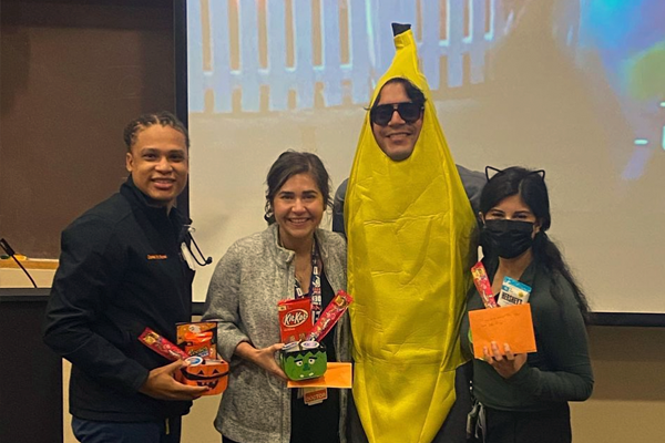 Three residents holding candy and one dressed as a banana