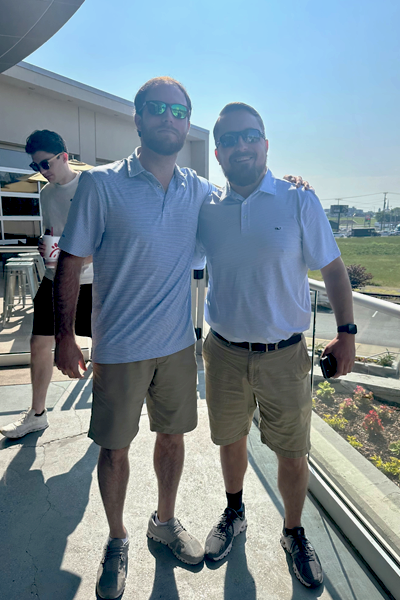 Two male residents outside with their arms around each other