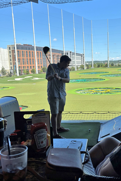 Male resident with a golf club about to drive a golf ball