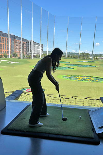 Female resident with a golf club about to drive a golf ball