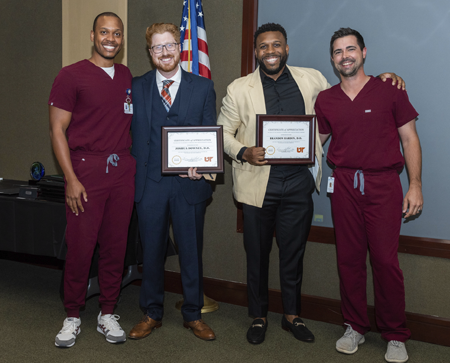 Male grads with certificates