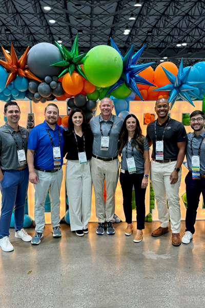 Residents and faculty at the conference with colorful balloons in the background