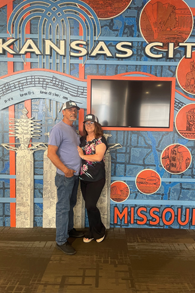 Program coordinator and her fiance before a Kansas City sign indoors