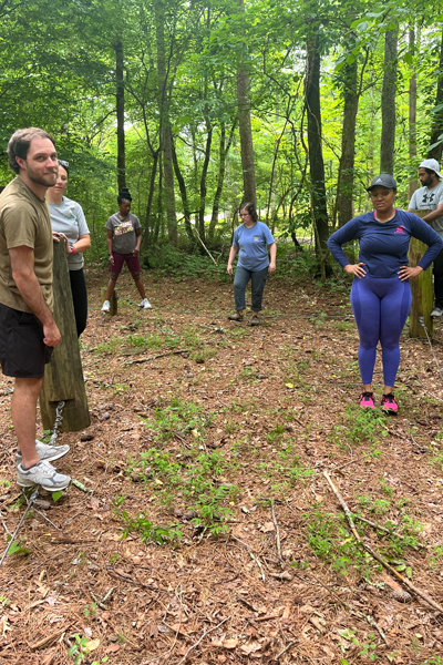 residents standing in the woods getting ready for the ropes course