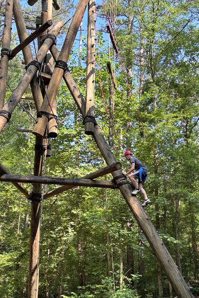 Resident climbing a structure in an outdoor training exercise