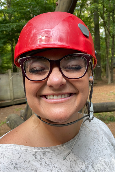 Female resident wearig a helmut and smiling with her eyes closed