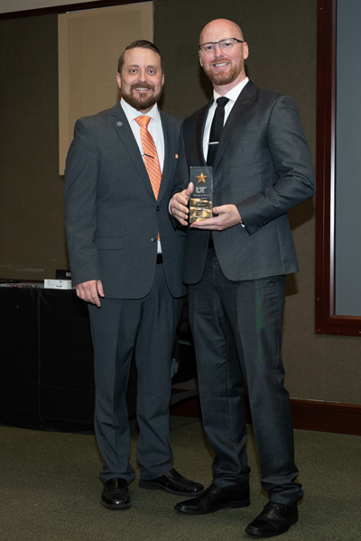 Faculty standing with a resident holding an award