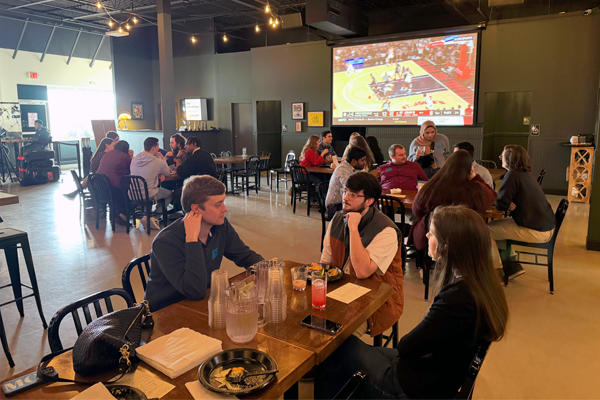 residents sitting in a restaurant with a television in the background