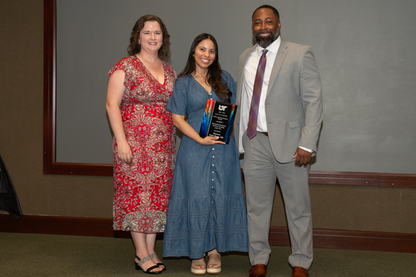 Faculty and resident with plaque at Graduation