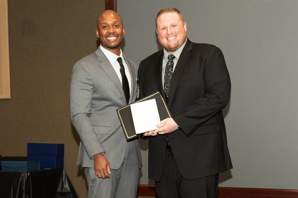Faculty and resident with an award at Graduation