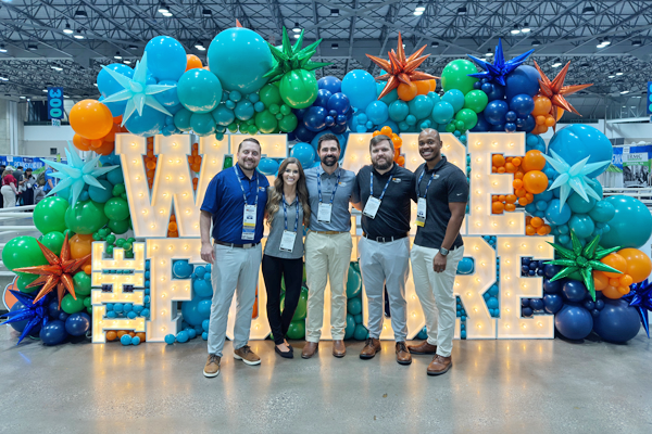 Faculty and residents in front of a lighted sign with balloons