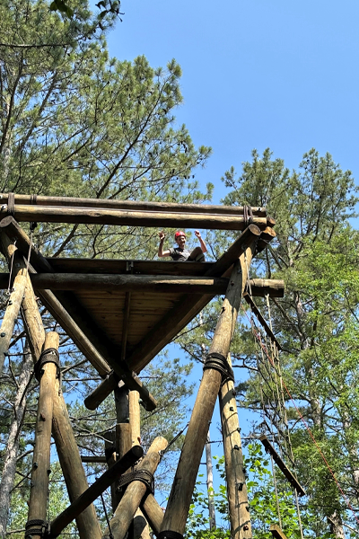 Resident climbing a structure in an outdoor training exercise