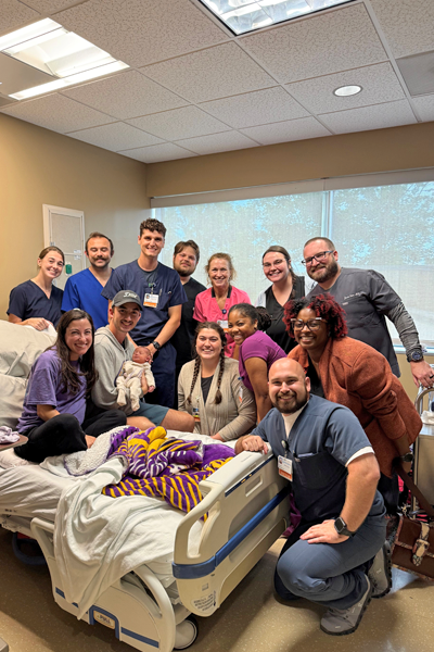 Resident who just gave birth surrounded by fellow residents in a hospital room
