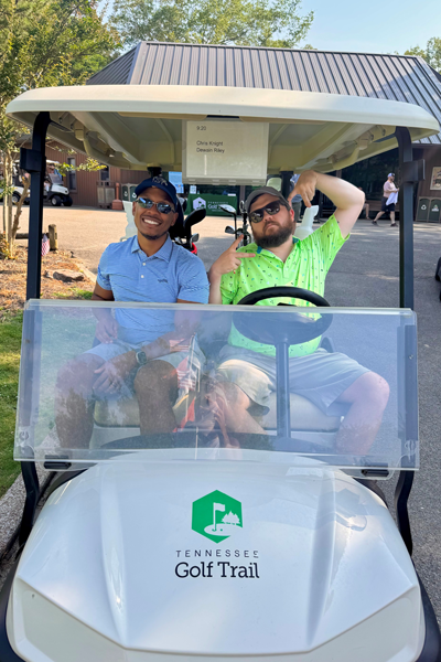 Male and female resident sitting in a golf cart on the golf course
