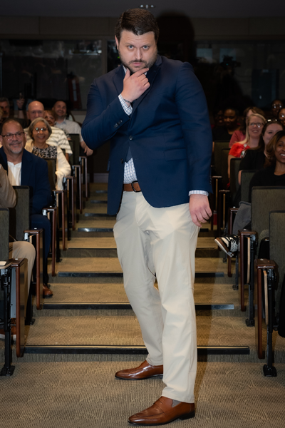 Male graduate posing in the aisle during graduation