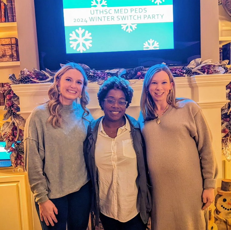 chief residents in front of a fireplace at a holiday party