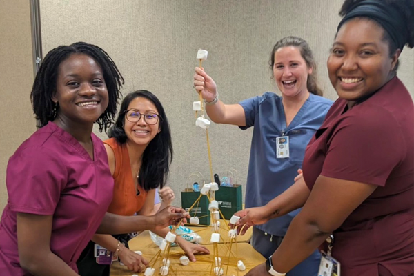 Female residents at a table with marshmallows on sticks