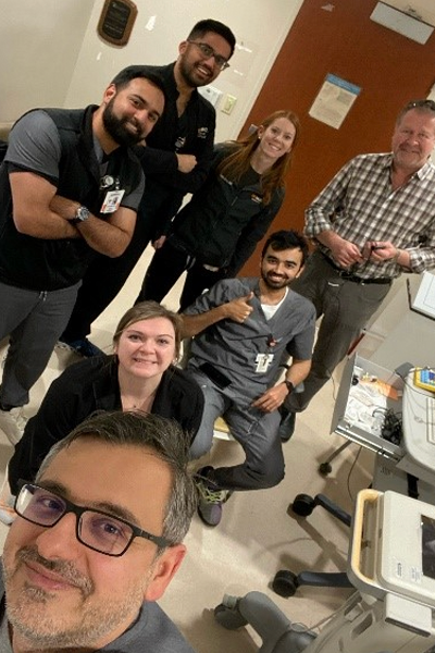 Fellows and faculty in a hospital room setting