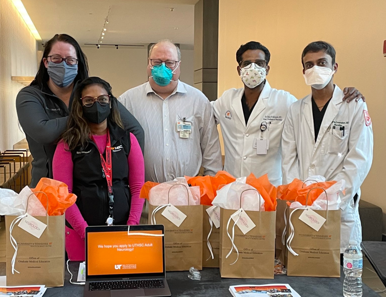 Residents and Dr. Malkoff with gift bags on a table in front of them