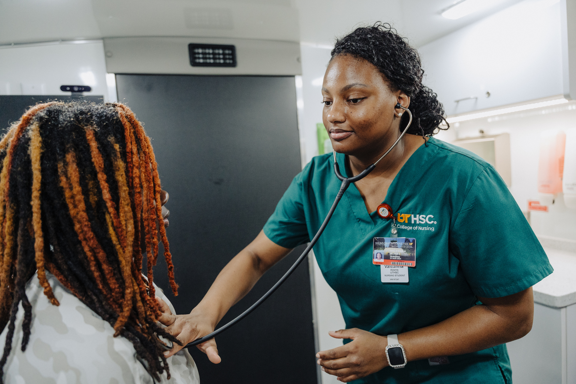 Nursing student examines a patient on a mobile health unit