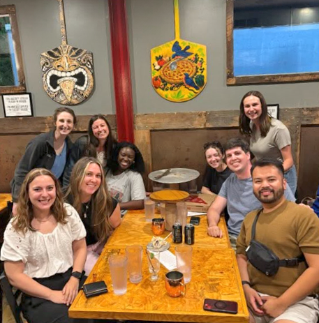 Residents sitting at a restaurant table with colorful paddles on the wall