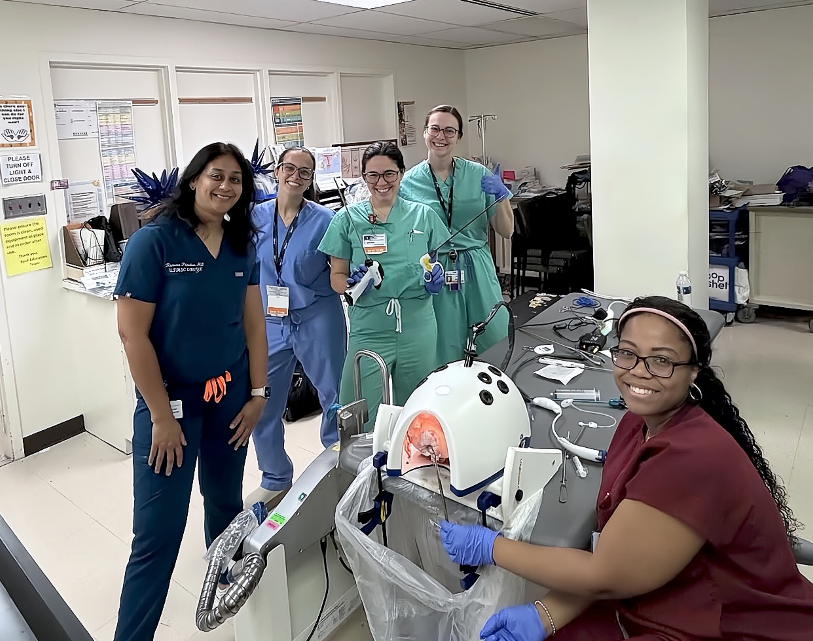 OB-GYN residents participating in a clinical simulation exercise using medical training equipment in a hospital simulation lab.