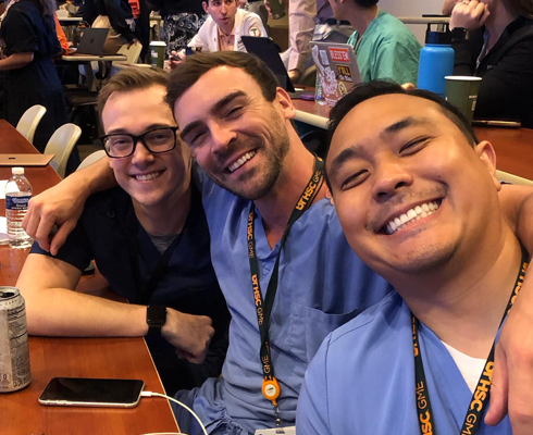 Three smiling male residents in a classroom setting