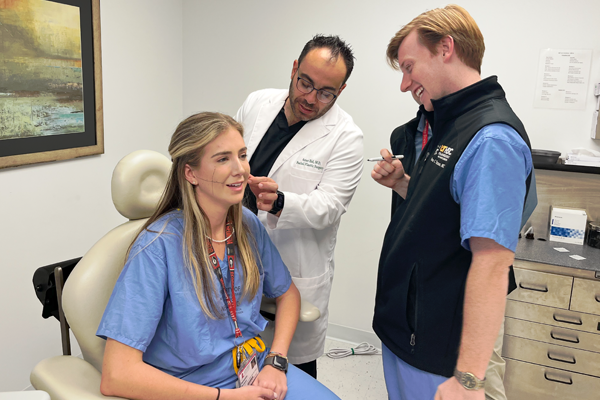 Resident learning from faculty working on a resident posing as a patient