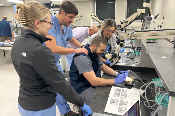 Residents working with equipment in lab setting