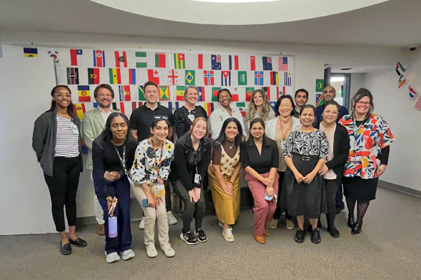 Group photo in front of colored flags