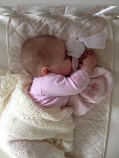 Baby sleeping on its side in the bed